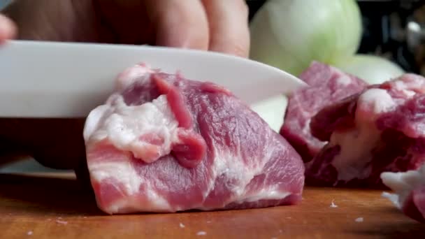 Samci ručně krájené kus syrového vepřového masa na kuchyňské desce — Stock video