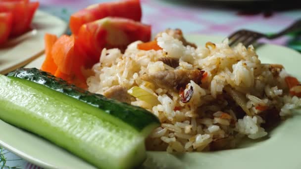 Arroz cozido com carne de porco, pepinos fatiados com pedaços de tomate — Vídeo de Stock