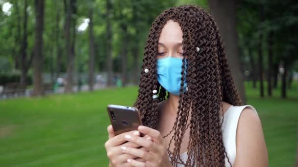 Stylový dlouhé kudrnaté vlasy dáma nosit ochrannou masku použití gadget — Stock video