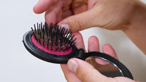 Непризнанные мужчины рука берет кучу волос на расческу — стоковое видео
