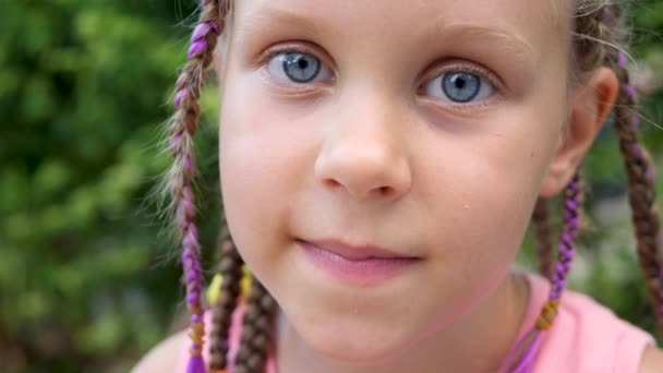 Симпатичная маленькая девочка улыбается и показывает первый wobby зуб — стоковое видео