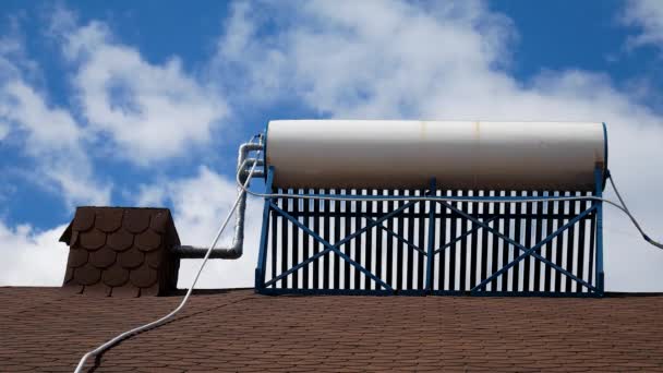 Rör sol varmvattenberedare på taket på blå himmel med moln bakgrund — Stockvideo