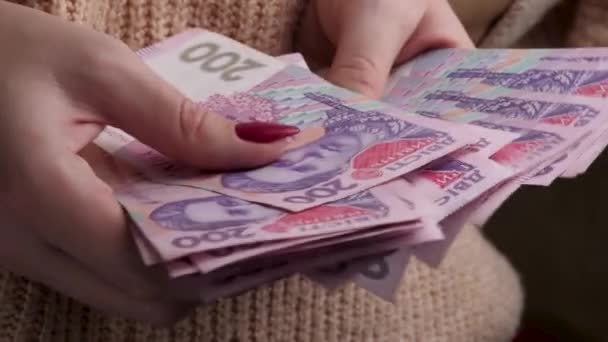Руки женщины считают украинские деньги гривной — стоковое видео
