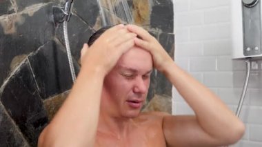 Tuvalette saç yıkayan bir erkek.
