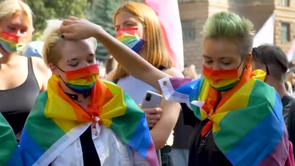 İki kadın renkli maske ve gökkuşağı bayrakları takıyor. — Stok video