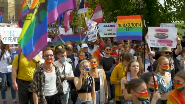 People with rainbow stuff walk at Pride parade — Stock Video