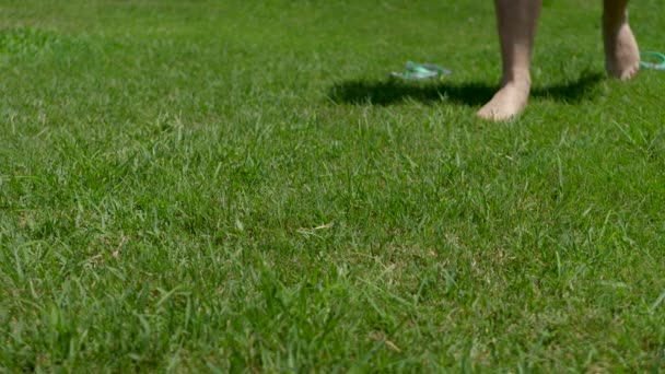 Barefooted onherkenbare man verblijf op groen gras — Stockvideo