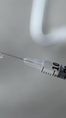 Aşı için tıbbi ekipmanlar hazır. Tam dozajlı şırınga ve iğne ucunda sıvı damlacıklar. Bulaşıcı tehditlere karşı bağışıklık sistemi desteği. Koruyucu sağlık hizmetleri çözümü