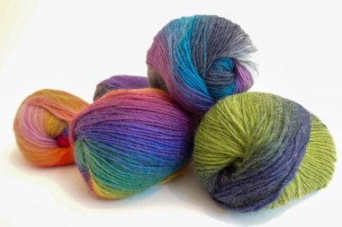 Bright multicolored skeins of yarn arranged on a clean white surface, symbolizing creativity, craft, and handmade textile art.