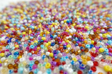 A vibrant close-up of small multicolored glass beads forming a playful and textured pattern, perfect for craft or jewelry design inspiration.