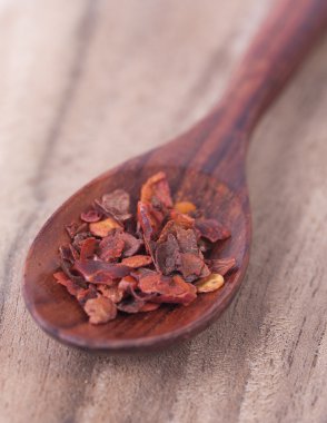 Fotoğraf kırmızı biber biber bir ahşap zemin üzerinde yer.