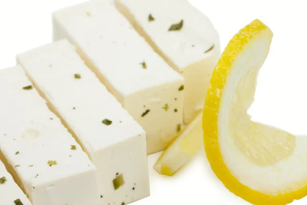 Blokken van Griekse feta kaas met Groenen en een stukje citroen Isola — Stockfoto