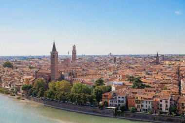 İtalya 'nın Verona kentinin havadan panoramik manzarası, Venedik bölgesindeki Adige Nehri üzerinde tarihi bir şehir, kırmızı tuğladan çatılar, ortaçağ sokakları ve kentsel manzara boyunca görkemli katedraller sergileniyor.