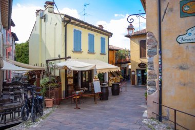 İtalya, Borghetto - 2 Ekim 2025: Sakin dar sokaklar, rahat kafeler ve tarihi taş binalarla dolu, huzurlu ve resimli bir köy atmosferi yaratıyor.