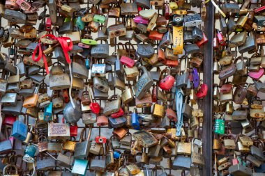 İtalya, Borghetto - 2 Ekim 2025: Sevgi ve bağlılığı sembolize eden renkli asma kilitler, ziyaretçiler tarafından nehir kenarındaki sevimli bir ortaçağ köy ortamında, şablon