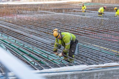 Espoo, Finlandiya - 20 Kasım 2025: Finnoo metro istasyonu yakınlarındaki Meritie, köprü ve yürüyüş yolu inşaatı sırasında demiryolu işçileri ile birlikte karayolu geliştirme