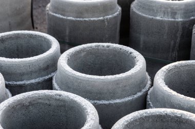 Beton borular istiflendi ve kanalizasyon inşaatı için hazırlandı. Drenaj ve kentsel altyapı geliştirme materyallerini gösteren sanayi şantiyesi