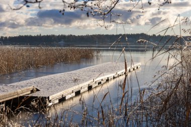 Baltık Denizi 'nde karla kaplı bir duba. Kuru otlarla çevrili. Kuzey kıyılarının saflığını, sakinliğini ve ekolojik güzelliğini gözler önüne seriyor.