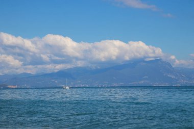 İtalya 'daki Garda Gölü, berrak mavi su, dağlar ve sakin göl manzaralı güzel bir manzara sergiliyor. Seyahat ve doğa fotoğrafçılığı için mükemmel.