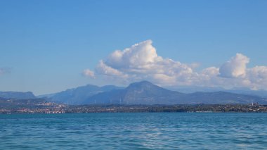 İtalya 'daki Garda Gölü, berrak mavi su, dağlar ve sakin göl manzaralı güzel bir manzara sergiliyor. Seyahat ve doğa fotoğrafçılığı için mükemmel.
