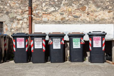 İtalya 'da kuru, ıslak ve yeşil atıklara etiketlenmiş seri atık ayıklama konteynerleri, yerel geri dönüşüm, çevre dostu uygulamalar ve sürdürülebilir atık yönetimi