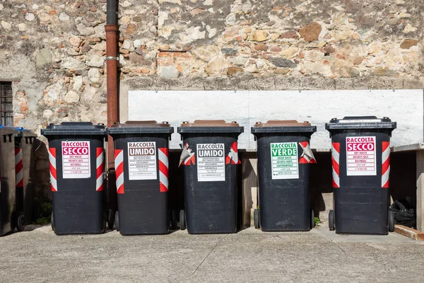 İtalya 'da kuru, ıslak ve yeşil atıklara etiketlenmiş seri atık ayıklama konteynerleri, yerel geri dönüşüm, çevre dostu uygulamalar ve sürdürülebilir atık yönetimi