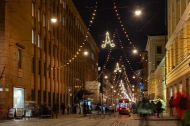 Helsinki, Finlandiya - 22 Aralık 2025: Aleksanterinkatu Noel için aydınlatıldı. Festivalin ışıklarıyla süslenmiş ana alışveriş caddesi, kış tatillerinde yerli ve turistlerin ilgisini çekiyor