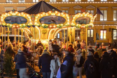 Helsinki, Finlandiya - 22 Aralık 2025: Helsinki Noel Pazarı Tuomaan Markkinat Senato Meydanı 'nda serbest stil atlıkarınca, ziyaretçi ve turistler