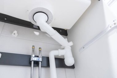 Lavabonun altında su tesisatı var. İçinde P-trap ve Hansgrohe sbox sistemi var. Organize boru ve fonksiyonel tasarımı gösteren modern kurulum