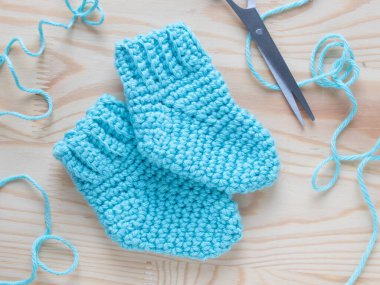 Bir çift açık mavi el işi bebek paçası. Bebekler için yumuşak, rahat ayakkabılar, yeni doğanlar için mükemmel hediyeler, ya da el yapımı aksesuarlar.