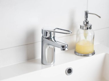 El yıkama ve hijyen konsepti. Cam makinesinde sıvı dezenfektan sabun ve banyoda musluk suyu, kapat. Kişisel hijyen, sağlık hizmetleri ve koronavirüs önleme