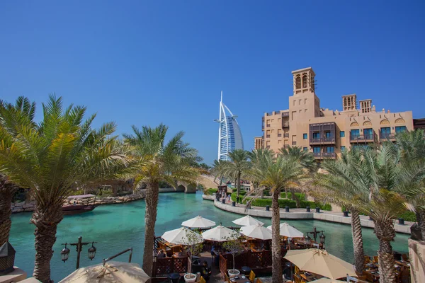 DUBAI, EMIRATOS ÁRABES UNIDOS - 11 DE ABRIL DE 2016: Vista del hotel Burj Al Arab desde el Souk Madinat Jumerirah con palmeras. 11 de abril de 2016 Dubai, Emiratos Árabes Unidos — Foto de Stock