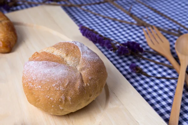 Upieczony chleb na tle drewniany stół — Zdjęcie stockowe