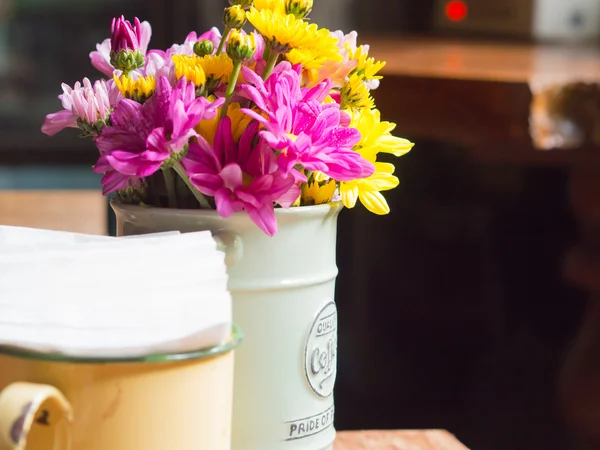 Jarrón con hierro y flores, estilo vintage sobre la mesa en las cafeterías . — Foto de Stock