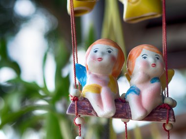 ağaç üzerinde asılı seramik bebek. 