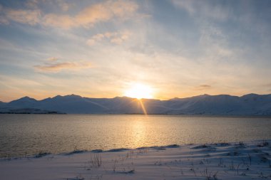 Kuzey İzlanda 'da Eyjafjordur fiyordunun üzerinde bir kış günü gün batımı