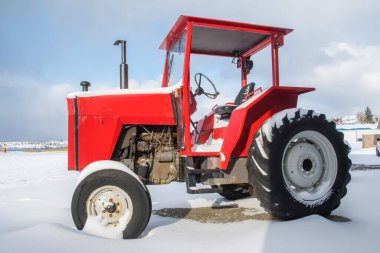 Güzel bir kar gününde güzel bir kırmızı traktör.