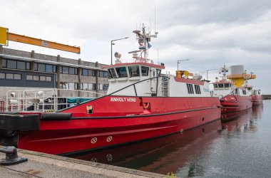 Grenaa Danimarka - 6 Haziran. 2024: Yel değirmeni tarlasında çalışan tekneler