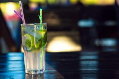 Mojito ahşap masaya sraws içkiyle kokteyl bardak