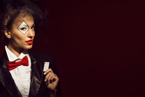 Retrato de uma jovem linda senhora croupier em uma imagem de brincalhão escondendo um cartão de ás — Fotografia de Stock