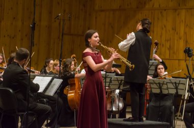 DNIPRO, UKRAINE - 23 Mart 2021: Oda Orkestrası - baş orkestra şefi Maria Shvets ve solist Anastasia Kukunina (soprano saksafon) M. Glinka 'nın adını verdikleri Dnipropetrovsk Müzik Akademisi' nde sahne aldılar..