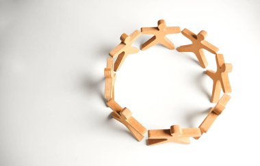 Birleşmiş ahşap figürlerden oluşan genel çember, ortak bir ağ içinde kapsayıcılığı, sıralı hedefleri ve bütünleşik işbirliğini göstermektedir..