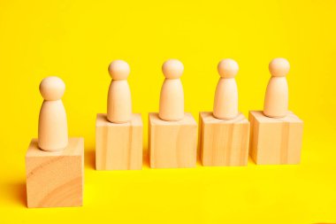 Yapılandırılmış bir liderlik boru hattı ve insan kaynakları değerlendirmesi kapsamında sıralama ve kariyer ilerlemesini gösteren blokların üzerinde duran beş ahşap figür.