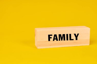 Vurgulanmış bir kelime engeli ile temsil edilen aile kavramı bağlantı, birlik ve paylaşılan aidiyeti simgeliyor.