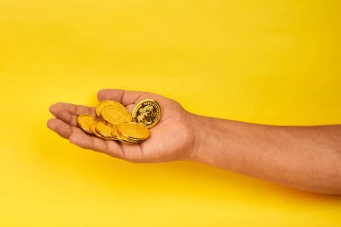 Tasarruf, refah, finansal hedefler ve gelecekteki fırsatlara yapılan kişisel yatırımları temsil eden altın sikkeler sunan bir el..