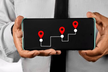 Lojistik planlamayı, dijital haritalamayı ve stratejik yönü sembolize eden, lojistik lojistik lojistik pimleri içeren bir navigasyon rotası gösteren bir akıllı telefon.