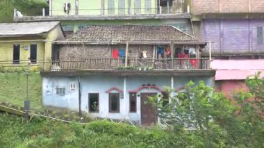 Desa Nepal Van Java, Magelang, Endonezya 'da günlük etkinlik, 27 Aralık 2022, huzurlu dağ köyündeki evinin balkonuna çamaşır asan bir kadın görülüyor..