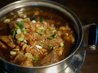 İçinde taze et ve aromatik otlar bulunan Endonezya Rawon siyah et çorbasının detaylı bir makro çekimi. Yüksek kaliteli aşçılık ve yemek menüsü tasarımları için mükemmel.