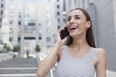 Gülümseyen ve telefonda konuşurken iş kadın portresi.