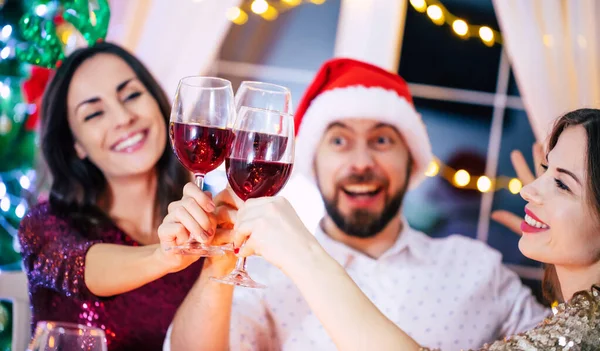 在一个家庭圣诞晚会上 一群快乐而又漂亮的朋友手拿着酒杯吃饭 玩得很开心 — 图库照片